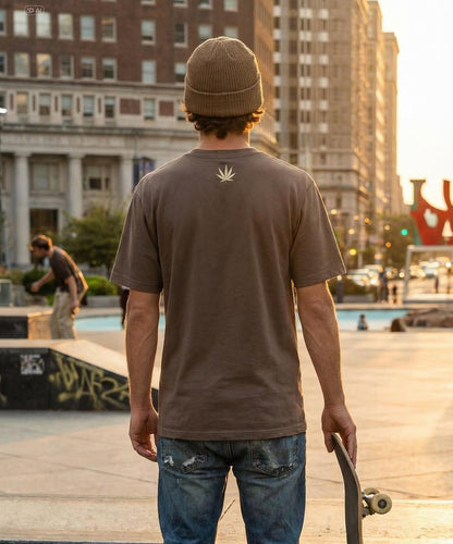 Less Organix Streetwear. Model auf der Strasse an einem Skateplatz. Rückansicht